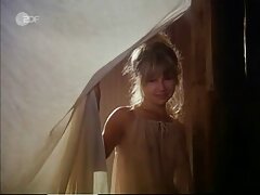 Encantadora en bata rosa y amiga disfrutan de una polla común en cámara